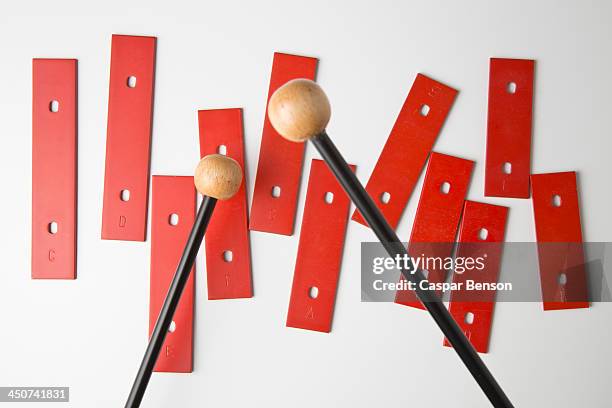 mallets preparing to play bars from a xylophone missing its base - xylophone stock-fotos und bilder