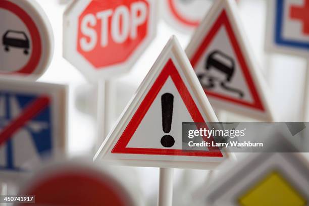 a toy hazard sign surrounded by other various road warning signs - road warning sign stock pictures, royalty-free photos & images