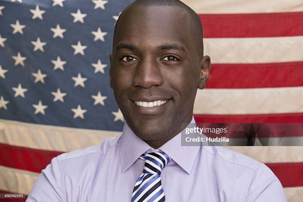 Smiling man in front of American flag