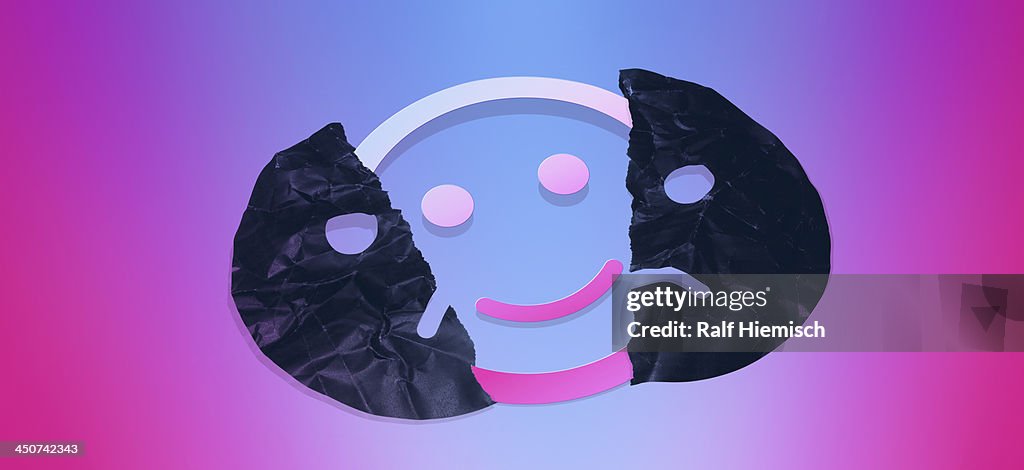 Graphic of a smiley face behind a torn sad face