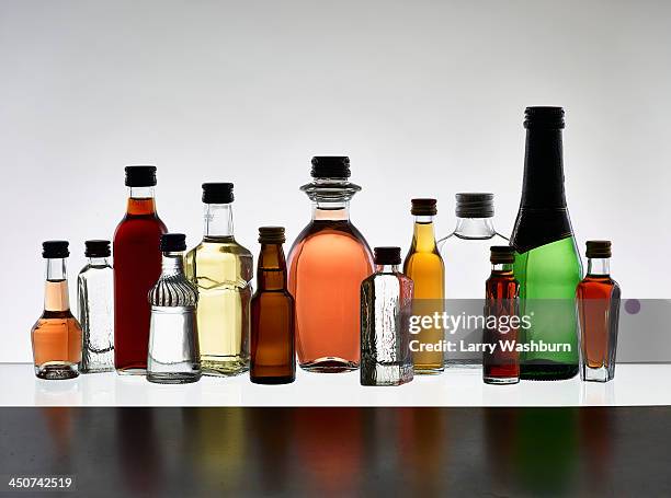 a grouping of various miniature bottles of alcohol without labels, back lit - hard liquor stock pictures, royalty-free photos & images