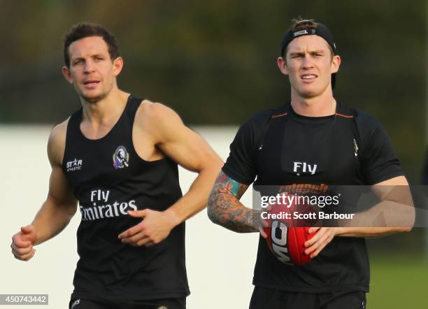 Luke Ball looks on as Dayne Beams of the Magpies runs with the ball during a Collingwood Magpies AFL training session on June 17, 2014 in Melbourne,...