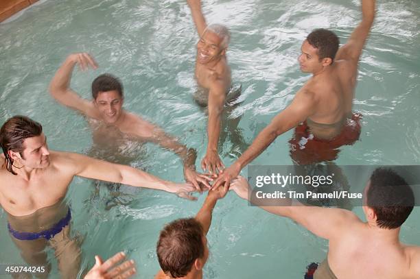 men playfully synchronize swimming - synchronized swimming photos et images de collection