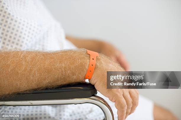 man with hospital wristband sitting - hospital identification bracelet stock pictures, royalty-free photos & images