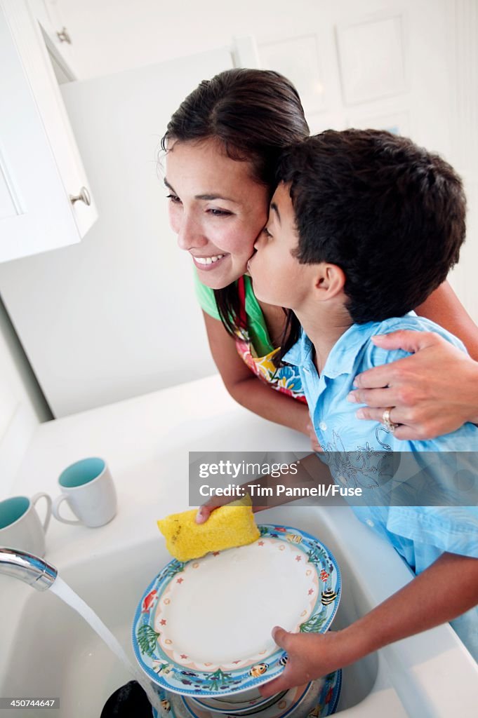 Son Kissing His Mom While Cleaning Dishes