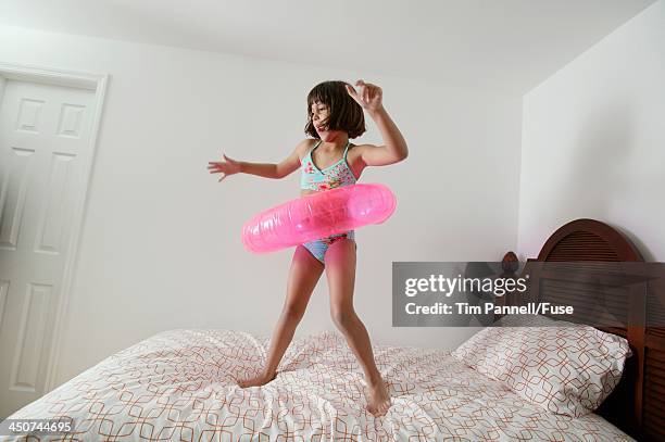 girl playing on bed with inflatable toy - domestic room imagens e fotografias de stock