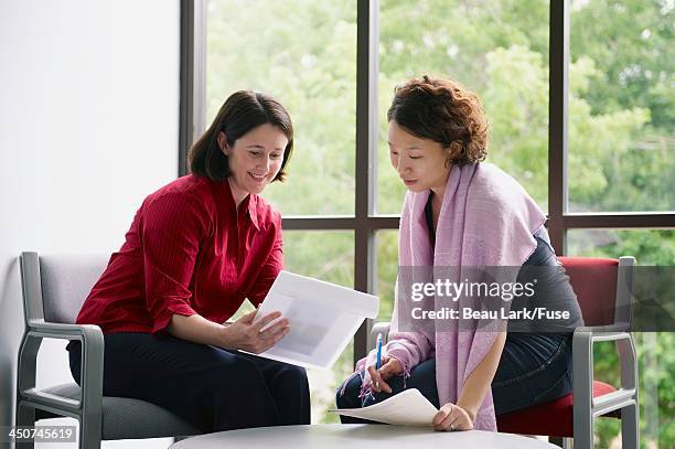 hospital administrator explaining paperwork to a patient - hospital paperwork stock pictures, royalty-free photos & images