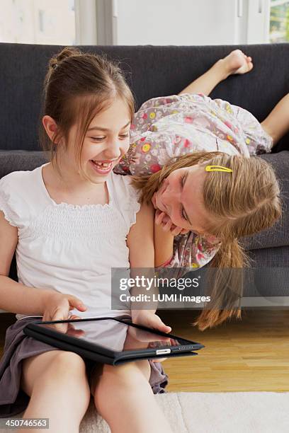 two girls (10-12) with tablet pc, munich, germany - girl 11 12 laughing close up foto e immagini stock