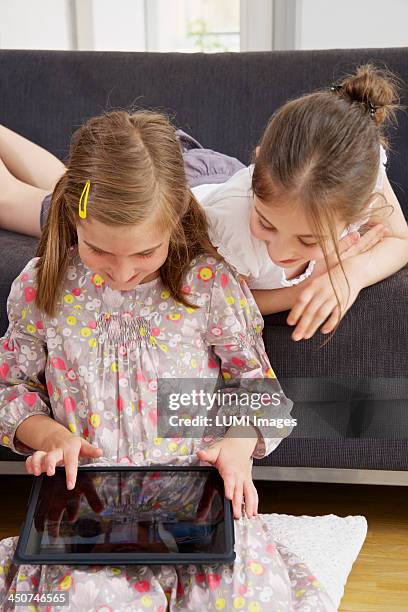 two girls (10-12) with tablet pc, munich, germany - girl 11 12 laughing close up foto e immagini stock