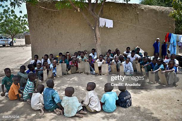 Muslim children write verses of the Quran on wooden slates to learn the holy Quran in Chad on June 16,2014.