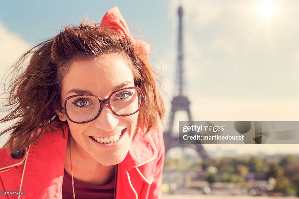 Retrato de mujer joven con gafas en la torre Eiffel.