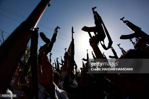Iraqi Shiite tribesmen brandish their weapons as they gather to show their willingness to join Iraqi security forces in the fight against Jihadist...