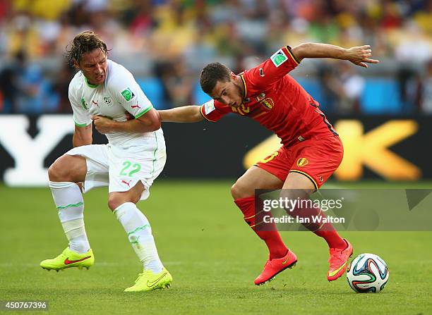 Eden Hazard of Belgium fights off Mehdi Mostefa of Algeria during the 2014 FIFA World Cup Brazil Group H match between Belgium and Algeria at Estadio...