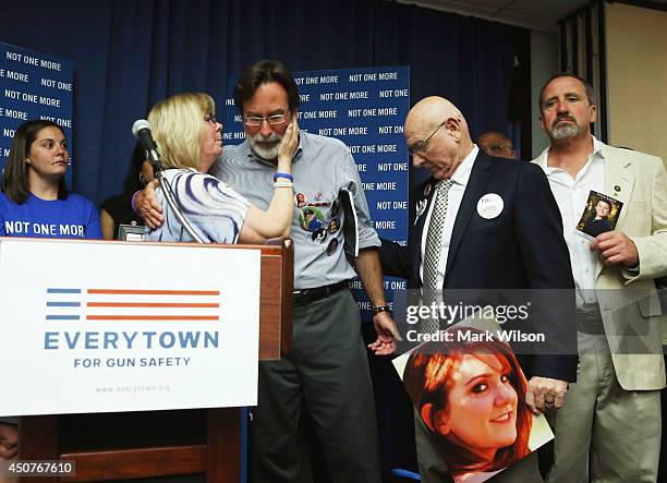 Richard Martinez comforts Sandy and Lonnie Phillips after they talked about their daughter Jessica Ghawi, who was shot and killed during a shooting...