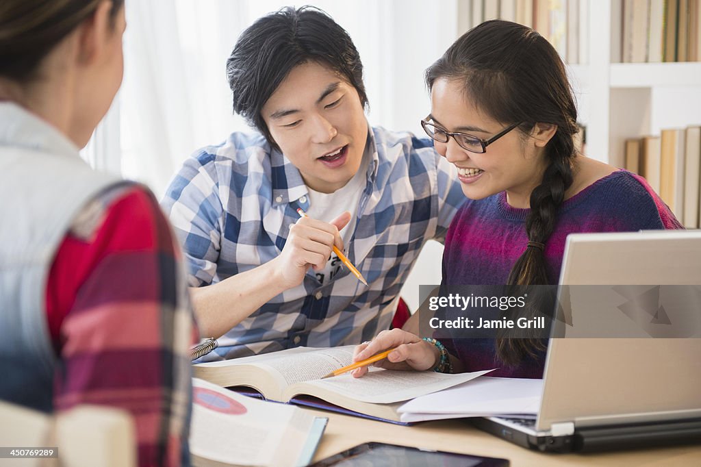 Young women and man studding in library