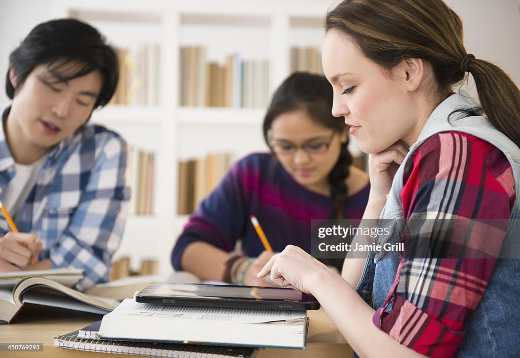 Young women and man studding in library