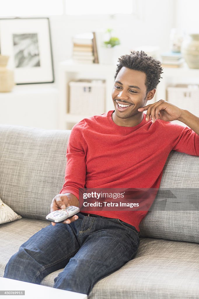 Man sitting on sofa and watching television