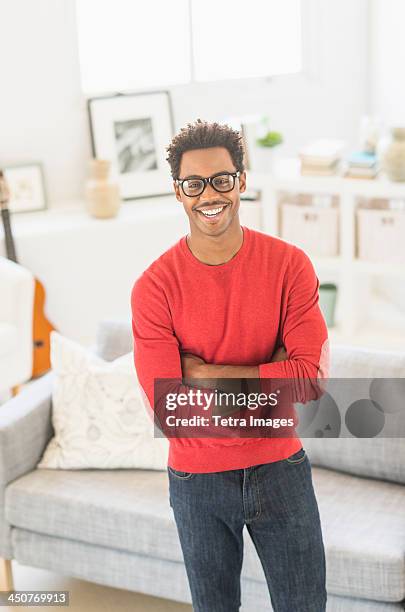 man wearing spectacles standing in living room - red tops stock pictures, royalty-free photos & images