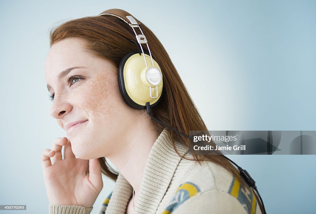 Teenage girl (14-15) with headphones, studio shot