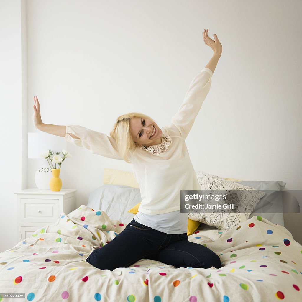 Young woman stretching in bed