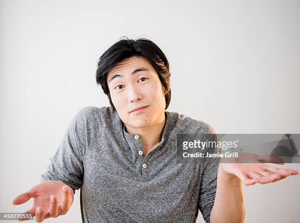 portrait of confused young man - apology stock pictures, royalty-free photos & images