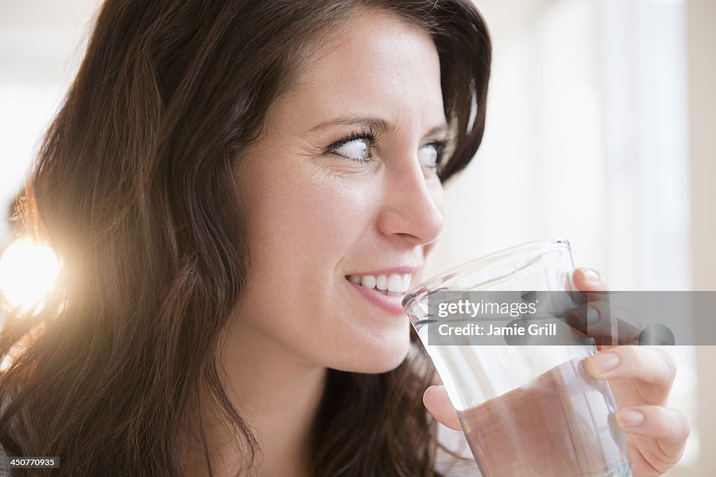 Portrait of young woman holding glass of water