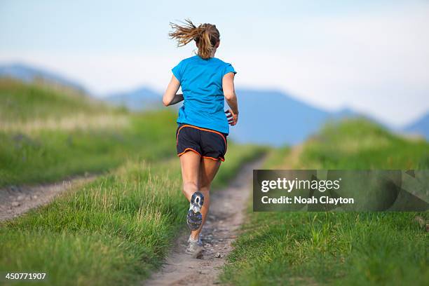 usa, montana, kalispell, rear view of young woman jogging - striding stock pictures, royalty-free photos & images