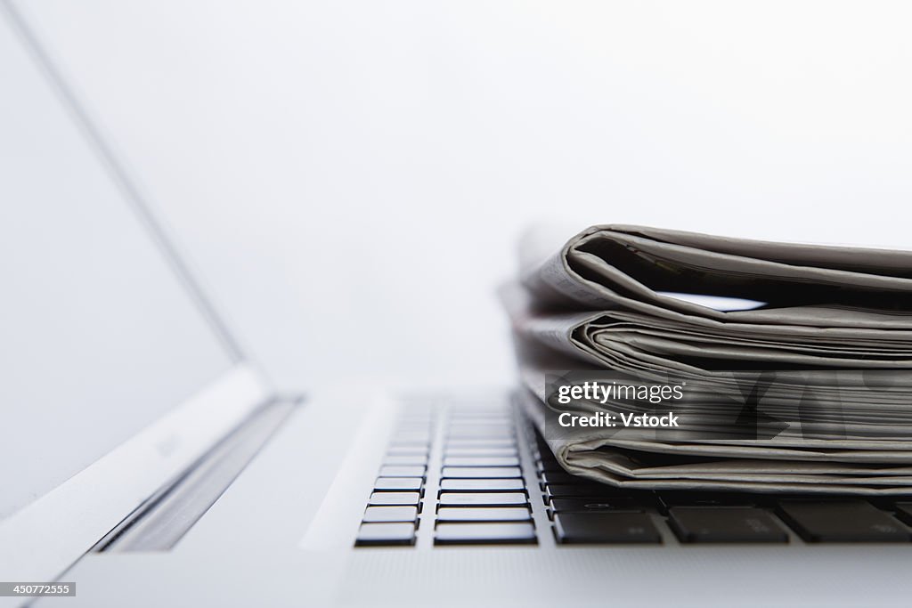 Stack of newspapers on laptop. close-up