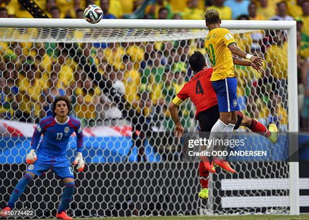 Brazil's forward Neymar and Mexico's defender Rafael Marquez jump for the ball in front of Mexico's goalkeeper Guillermo Ochoa during a Group A...