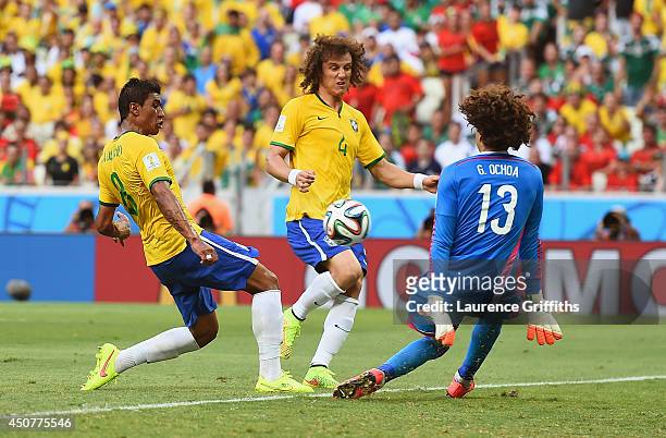Guillermo Ochoa of Mexico makes a save from Paulinho of Brazil as David Luiz looks on during the 2014 FIFA World Cup Brazil Group A match between...