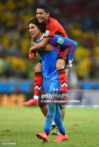 Goalkeeper Guillermo Ochoa of Mexico celebrates with Javier Aquino after their 0-0 draw with Brazil during the 2014 FIFA World Cup Brazil Group A...