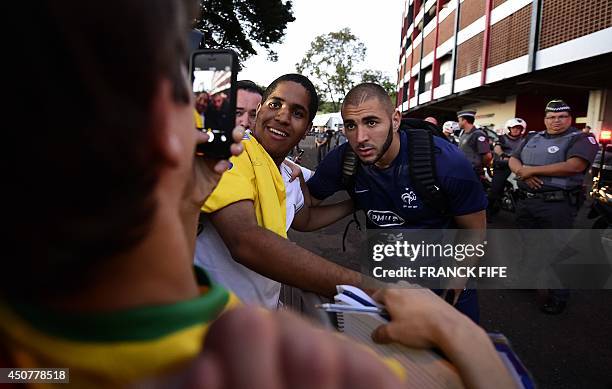 France's forward Karim Benzema poses with a fans at the end of a training session at the stadium Santa Cruz in Ribeirao Preto on June 17 during the...