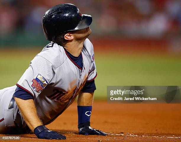 Brian Dozier of the Minnesota Twins looks up at the umpire after sliding into first base against the Boston Red Sox during the game at Fenway Park on...