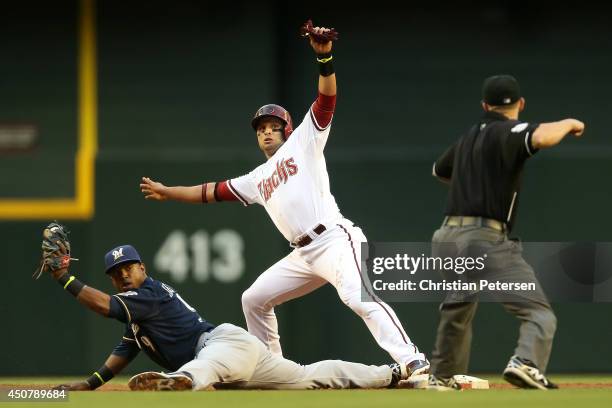 Martin Prado of the Arizona Diamondbacks is called out at second base after a force out by infielder Jean Segura of the Milwaukee Brewers during the...