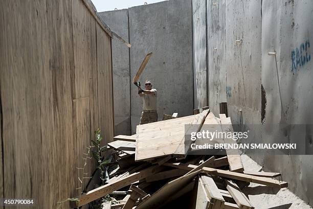 Afghanistan-election-US-unrest,FOCUS by Dan De Luce This photo taken on June 2, 2014 shows a US soldier throwing wood onto a pile during the...