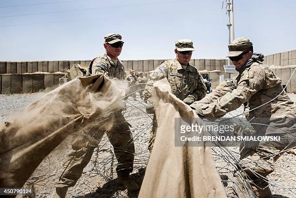 Afghanistan-election-US-unrest,FOCUS by Dan De Luce This photo taken on June 2, 2014 shows members of the US Army demolishing Hesco barriers ahead of...