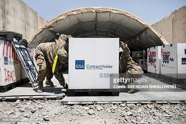 Afghanistan-election-US-unrest,FOCUS by Dan De Luce This photo taken on June 2, 2014 shows US soldiers marking a box used to sort and ship materials...
