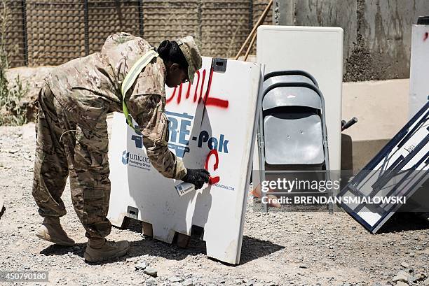 Afghanistan-election-US-unrest,FOCUS by Dan De Luce This photo taken on June 2, 2014 shows a US soldier marking a box used to sort and ship materials...