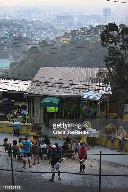People watch the Brazil vs Mexico World Cup match on a television setup in a house located in a favela known as Prazeres as the FIFA World Cup...