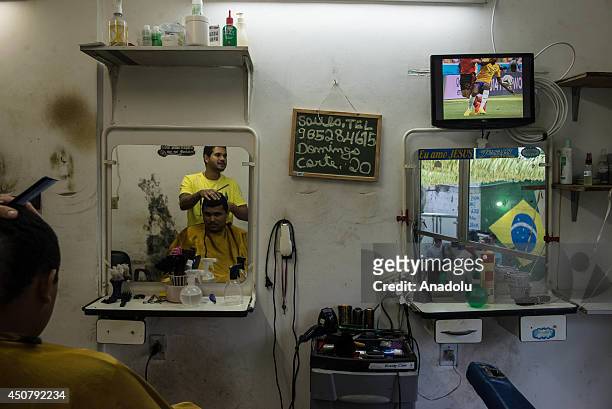 Residents of Rocinha Favela in Rio de Janeiro watch their national team's match against Mexico on the screens in Brazil, June 17, 2014. Brazil, the...