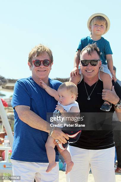 Elton John and David Furnish with their children leaving Club 55 restaurant after lunch on August 22, 2013 in Saint Tropez,France.