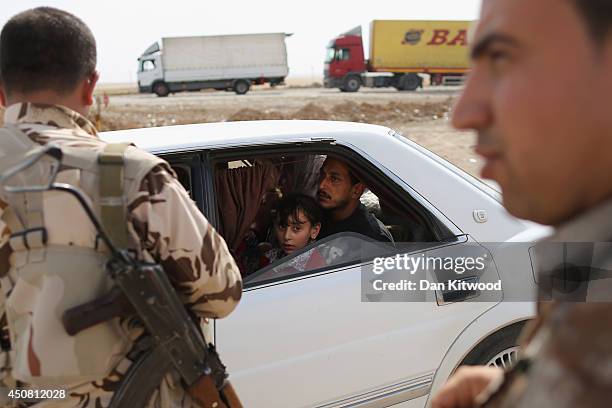 Peshmerga military direct traffic at a Kurdish Check point on June 14, 2014 in Kalak, Iraq. Thousands of people have fled Iraq's second city of Mosul...