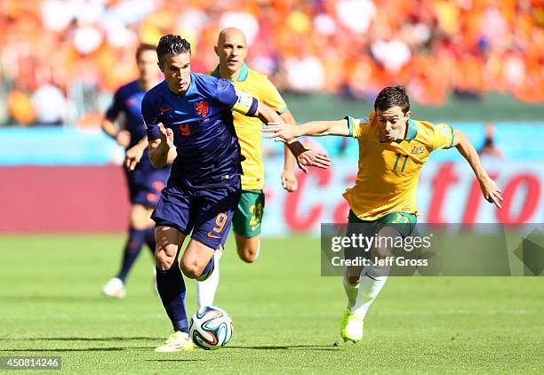 Robin van Persie of the Netherlands controls the ball against Tommy Oar of Australia during the 2014 FIFA World Cup Brazil Group B match between...