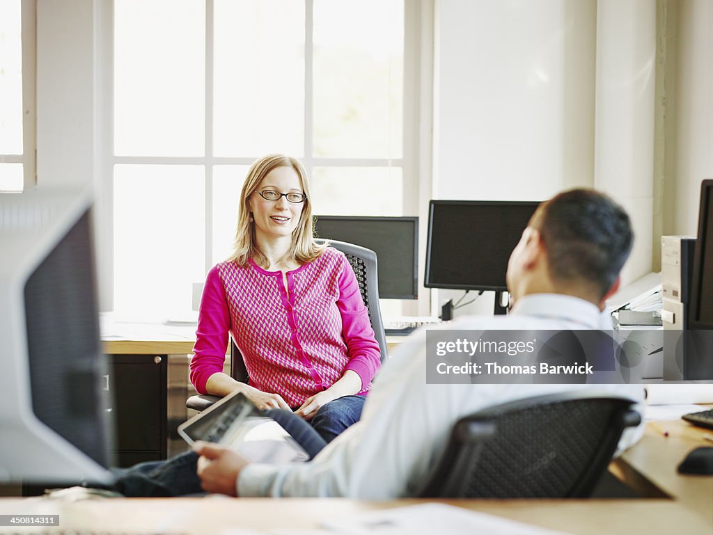 Coworkers discussing project in office