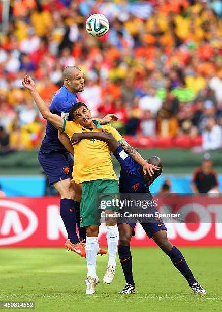 Tim Cahill of Australia competes for the ball with Ron Vlaar and Bruno Martins Indi of the Netherlands during the 2014 FIFA World Cup Brazil Group B...