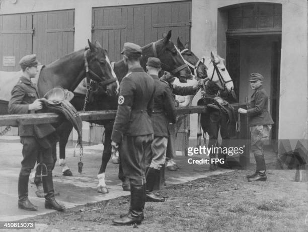 Young Hitler Youth recruits, being trained as horse grooms by German soldiers during World War Two, Germany, circa 1939-1945.