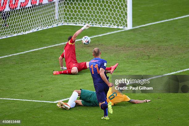 Arjen Robben of the Netherlands shoots and scores his team's first goal past goalkeeper Mathew Ryan of Australia during the 2014 FIFA World Cup...