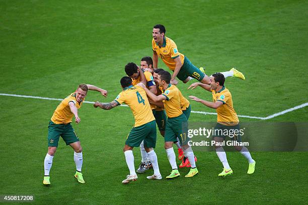 Mile Jedinak of Australia celebrates scoring his team's second goal with teammates during the 2014 FIFA World Cup Brazil Group B match between...