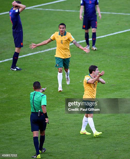 Referee Djamel Haimoudi signals for a penalty kick as Tim Cahill and Tommy Oar of Australia react during the 2014 FIFA World Cup Brazil Group B match...