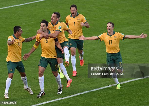Australia's midfielder and captain Mile Jedinak celebrates with teammates after scoring on a penalty kick during a Group B football match between...